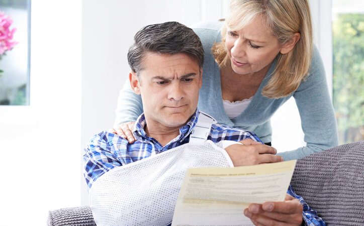 Man in bandage looking at psychological report with wife